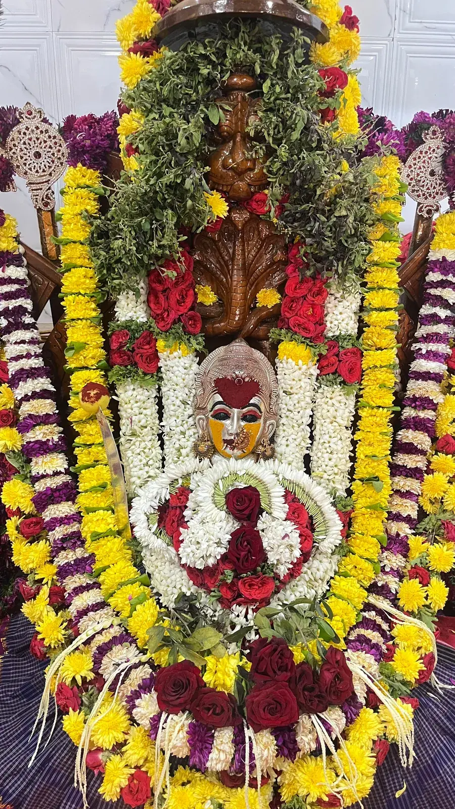 ಚೆಂಡು ಹೂವು ಮತ್ತು ಕೆಂಪು ಹೂವುಗಳ ಹಾರಗಳಿಂದ ಅಲಂಕೃತಳಾದ ದೇವಿ